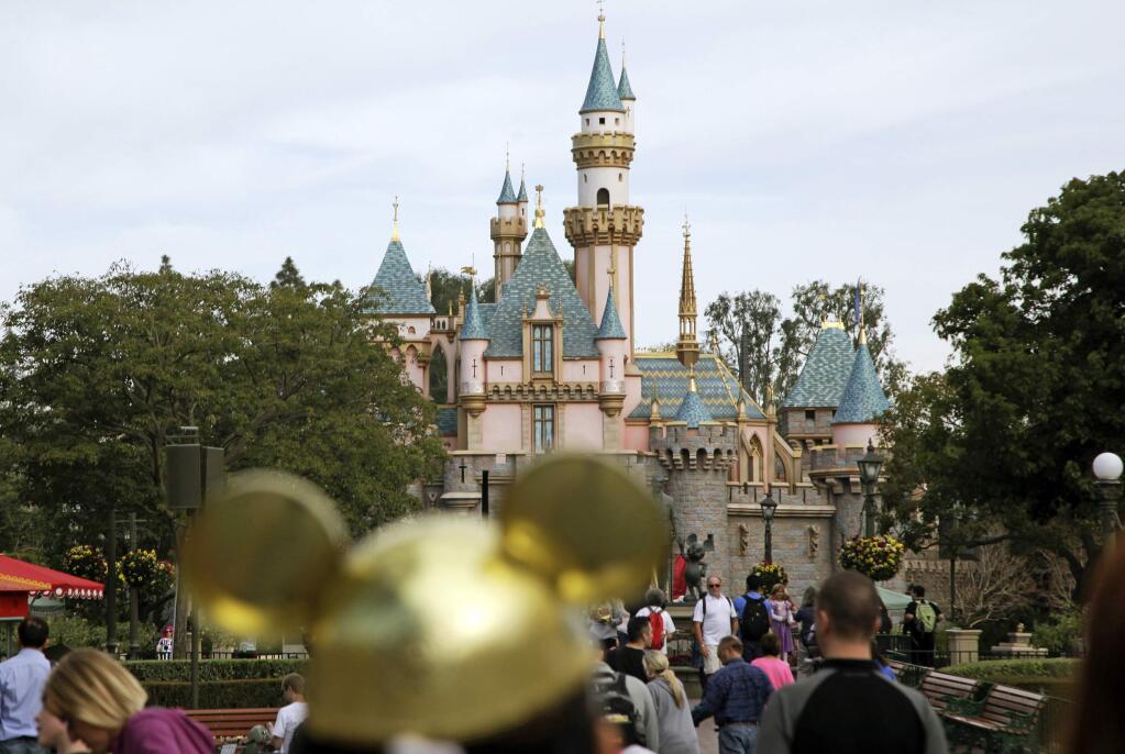FILE - In this Jan. 22, 2015 file photo, visitors walk toward Sleeping Beauty's Castle at Disneyland Resort in Anaheim, Calif. (AP Photo/Jae C. Hong, File)