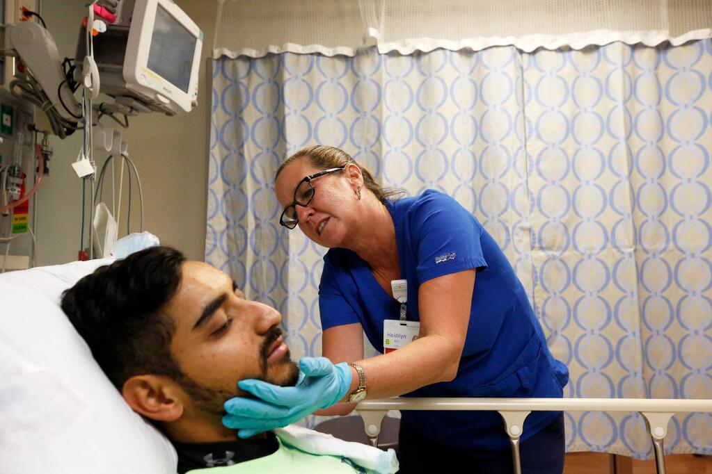 Emergency department nurse Heidilyn Brunsmann tends to an injury on patient Luis Higareda at Healdsburg District Hospital, which reopened earlier this week after the Kincade Fire, in Healdsburg, California, on Friday, November 22, 2019. (Alvin Jornada / The Press Democrat)