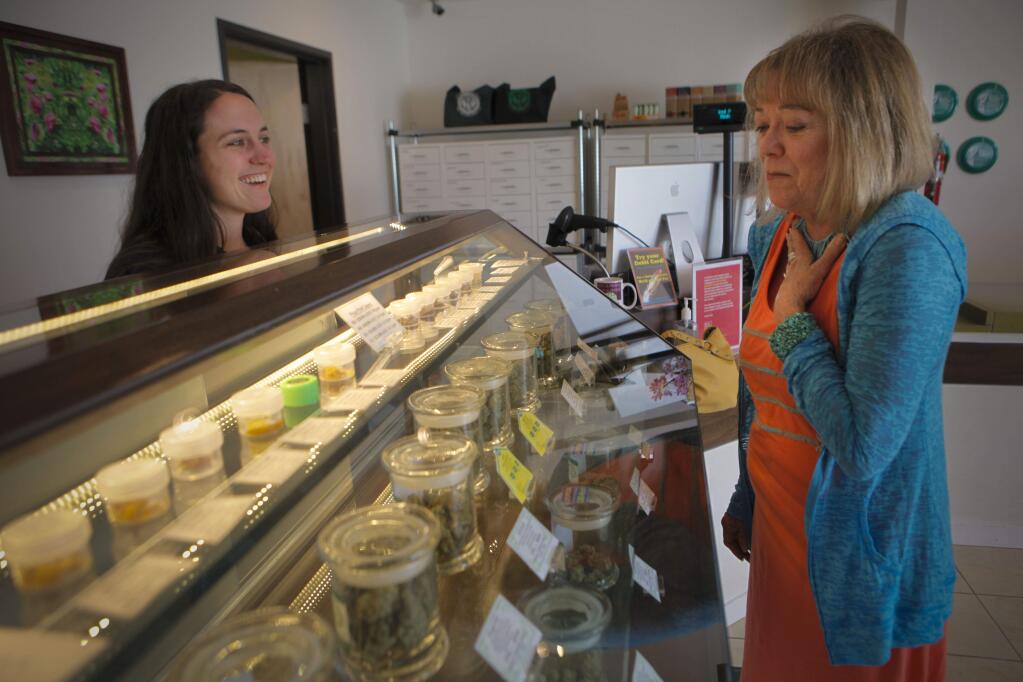 Petaluma, CA, USA. Tuesday, July 26, 2016._ Ashley Nelson, the Operations Manager at Peace in Medicine in Santa Rosa describes some the medical marijuana on display at the shop to Linda Stokely of Petaluma. Stockely, 66, who is very physically active says that the marijuana which she uses as salves or edibles or in a vaporizer do not give her the bad side effects she got from prescription medication. (CRISSY PASCUAL/ARGUS-COURIER STAFF)