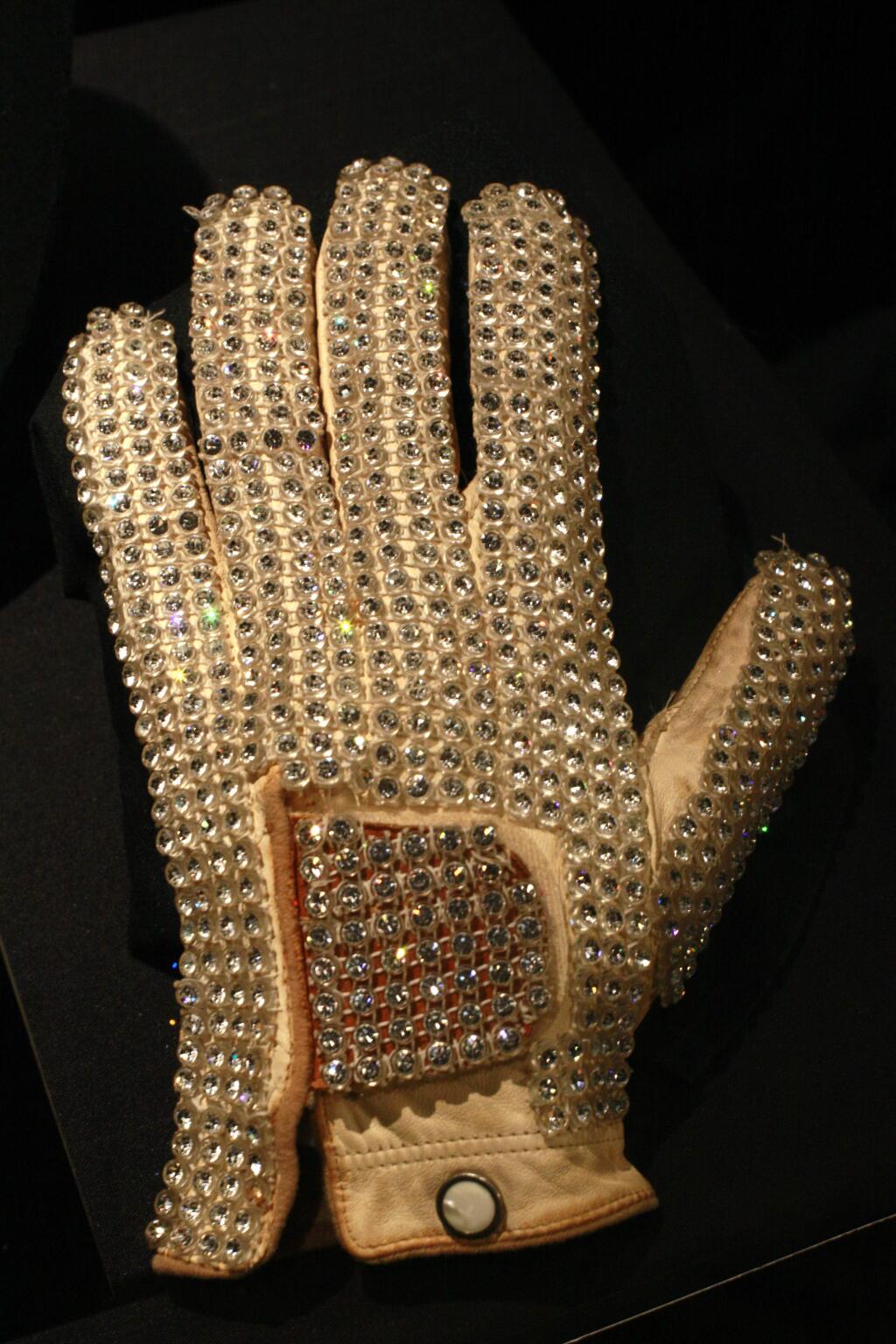 FILE - In this Nov. 21, 2009, file photo, Michael Jackson's glove from his 1983 performance of Billie Jean at the Motown 25 television special where he performed the Moonwalk for the first time is on display at the Hard Rock Cafe in New York's Times Square. Julien's Auctions announced on Oct. 13, 2017, that a white glove Jackson wore on his 'Triumph' tour is among several Jackson memorabilia items set to go up for bid on Nov. 4. (AP Photo/Mary Altaffer, File)