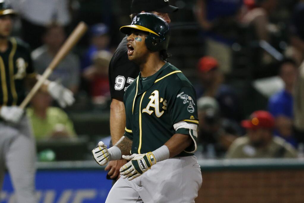 Oakland Athletics Khris Davis celebrates as the crosses home after hitting a three-run home run in the 10th inning of the team's baseball game against the Texas Rangers, Tuesday, July 24, 2018, in Arlington, Texas. The A's won 13-10. (AP Photo/Roger Steinman)