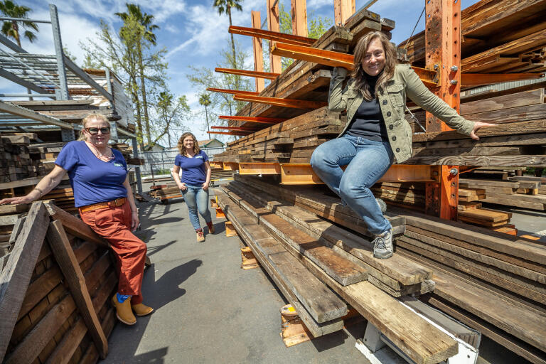 Nicole Tai, right owner of GreenLynx, along with store manager Stephanie Melnik, center and visual merchandiser Annie Schlicter, left, in the lumber yard of the Santa Rosa re-use company which specializes in deconstructing buildings and salvaging any materials for resale and re-use. (Chad Surmick / The Press Democrat)