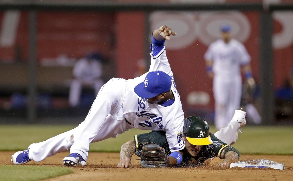Kansas City Royals shortstop Alcides Escobar (2) and Oakland Athletics' Brett Lawrie become entangled after Lawrie was forced out during the seventh inning of a baseball game Friday, April 17, 2015, in Kansas City, Mo. (AP Photo/Charlie Riedel)