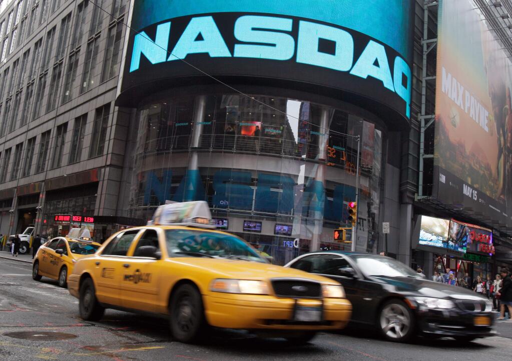 FILE - In this May 16, 2012 file photo, a taxi passes in front of the Nasdaq MarketSite in New York's Times Square. Fifteen years after peaking during the dot-com boom, the Nasdaq composite has reached a new all-time high on Thursday, April 23, 2015. (AP Photo/Richard Drew, File)