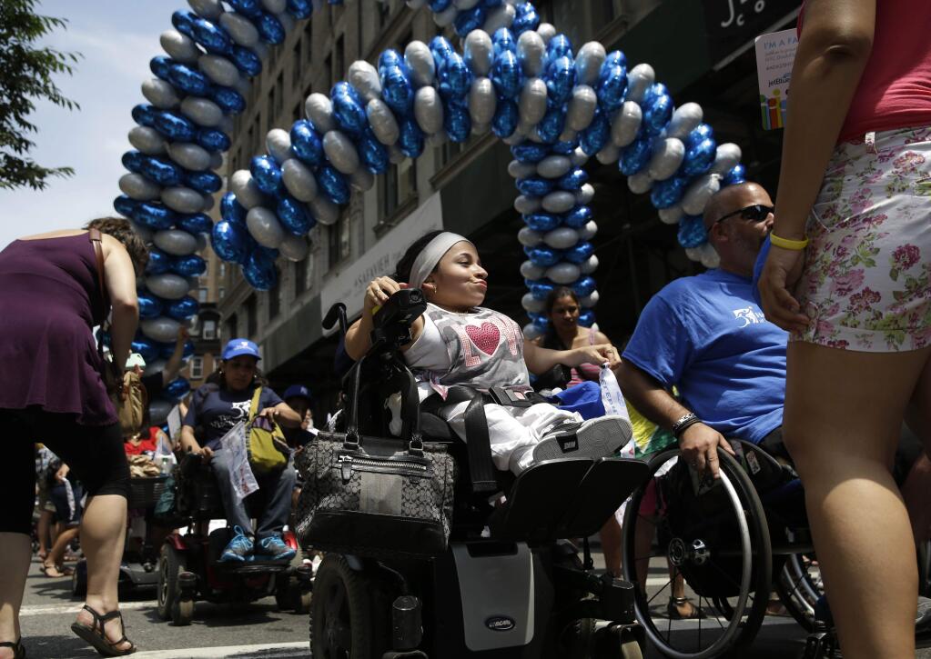 Jessica Lopez, center, participates in the inaugural Disability Pride Parade, Sunday, July 12, 2015, in New York. The parade grand marshal was former U.S. Sen. Tom Harkin, the Iowa Democrat who 25 years ago sponsored the Americans With Disabilities Act. (AP Photo/Seth Wenig)