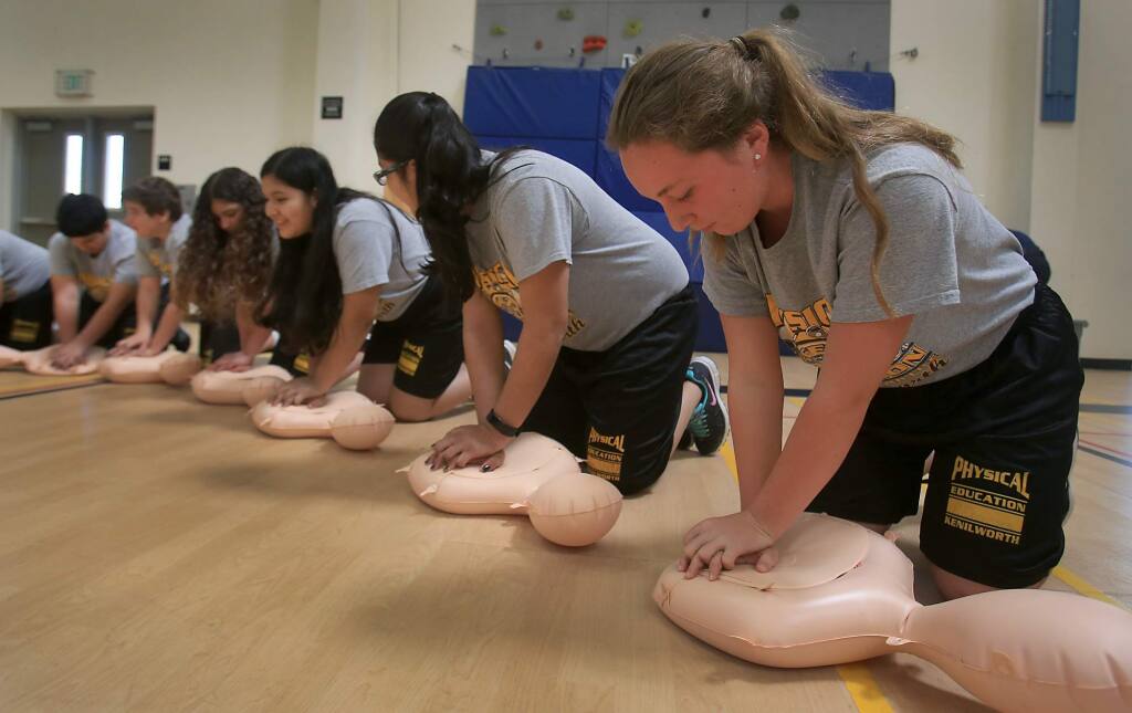 Megan Johnson, right, joins her classmates in a CPR instruction that was put on by the Petaluma Fire Department, Thursday March 30, 2017 at Kenilworth Jr. High in Petaluma. (Kent Porter / The Press Democrat) 2017