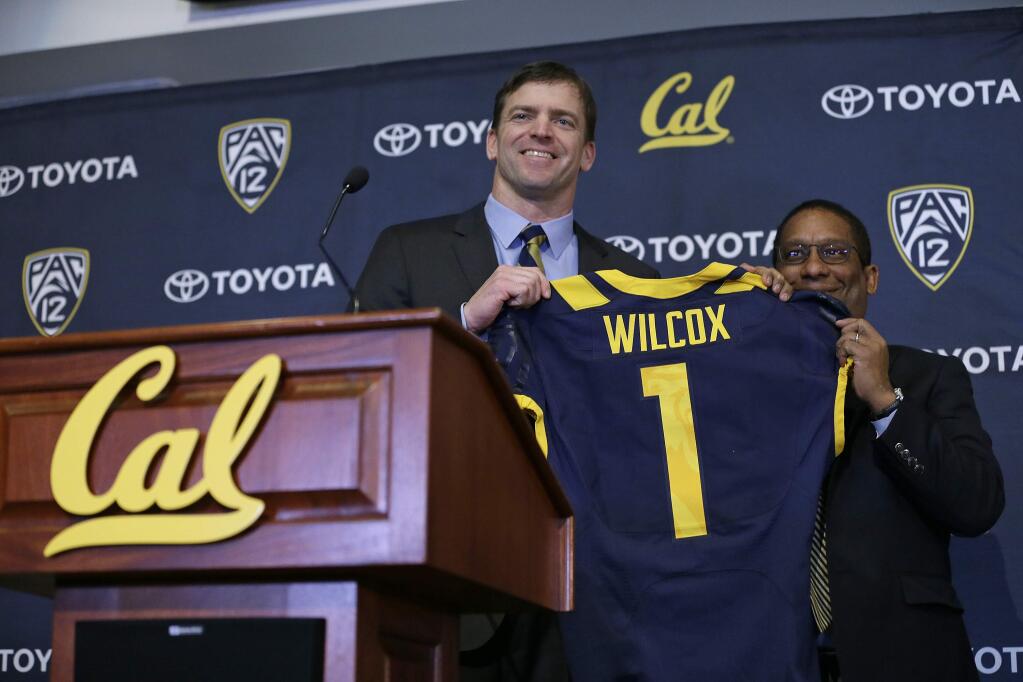 Cal football coach Justin Wilcox, left, is presented a jersey by Director of Athletics Mike Williams, right, during a news conference Tuesday, Jan. 17, 2017, in Berkeley. Cal officially introduced Wilcox, hoping the long-time defensive coordinator can help revive the struggling program. (AP Photo/Eric Risberg)