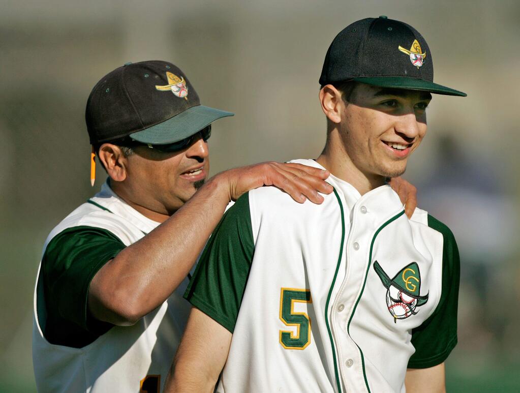 Casa Grande Coach Paul Maytorena pats pitcher Dominic Garihan on the back for pitching a shutout against Montgomery High School, at Casa Grande in Petaluma, Calif., on April 17, 2013. Casa Grande won the game with a score of 1-0. (Alvin Jornada / The Press Democrat)