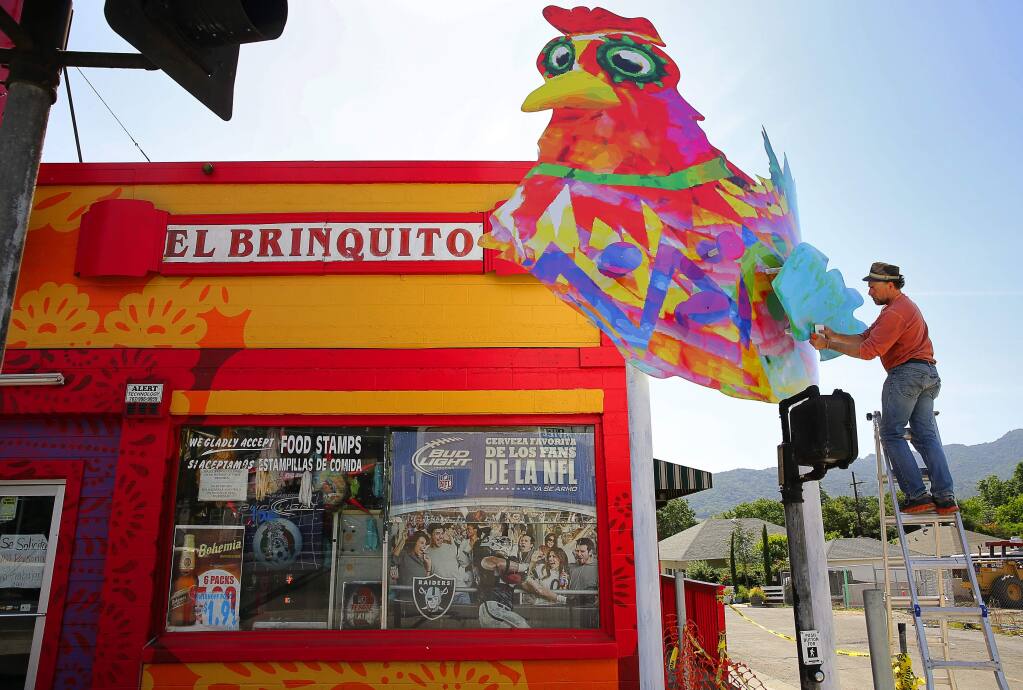 Artist Rico Martin works on his 'Springs Chicken' in front of El Brinquito, in the Boyes Hot Springs area of Sonoma Valley, on Tuesday, April 26, 2016. (Christopher Chung/ The Press Democrat)