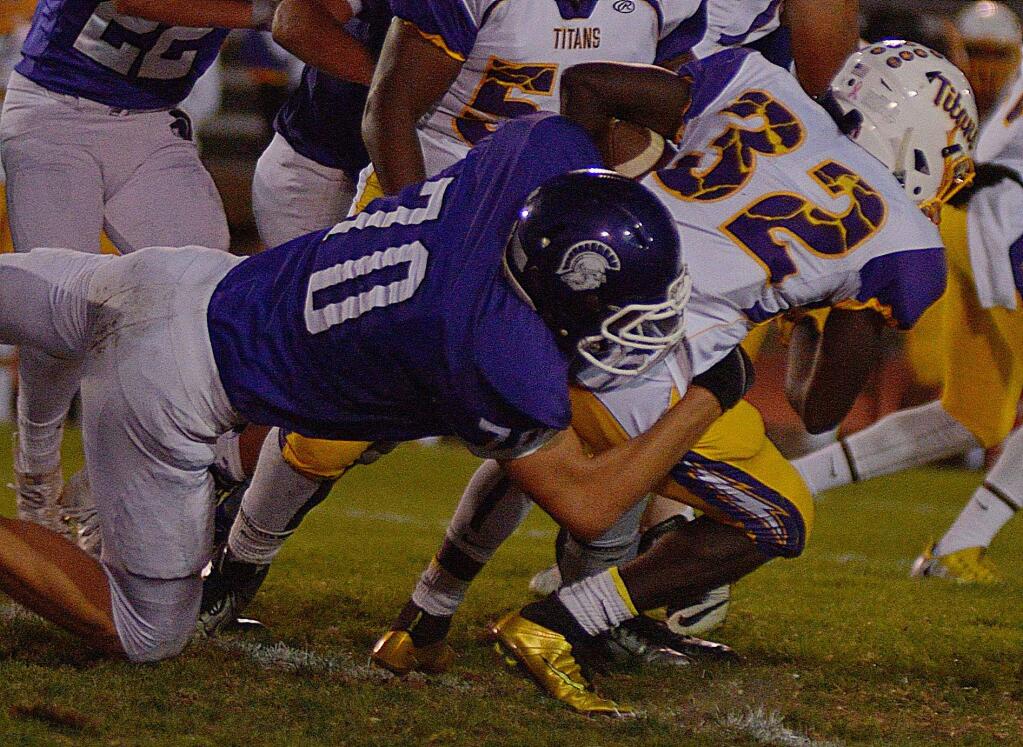 SUMNER FOWLER/FOR THE ARGUS-COURIERPetaluma's Luke Haggard brings down a Kennedy ball carrier in the non-league game played at Steve Ellison Field.