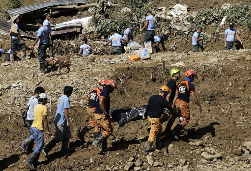 Rescuers carry a body they recovered at the site where victims are believed to have been buried by a landslide after Typhoon Mangkhut lashed Itogon, Benguet province, northern Philippines on Monday, Sept. 17, 2018. Itogon Mayor Victorio Palangdan said that at the height of the typhoon's onslaught Saturday afternoon, dozens of people, mostly miners and their families, rushed into an old three-story building in the village of Ucab. The building, a former mining bunkhouse that had been transformed into a chapel, was obliterated when part of a mountain slope collapsed. (AP Photo/Aaron Favila)