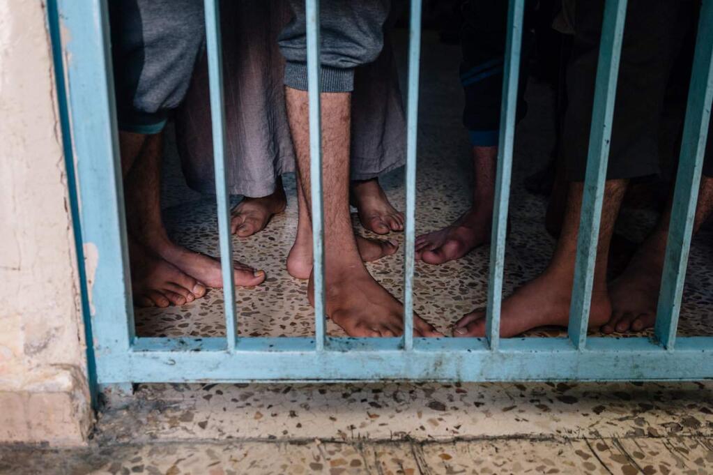 Prisoners accused of being Islamic State militants stand in a cell on June 1, 2019, in Qamishli, Syria. (PHOTO FOR THE WASHINGTON POST BY ALICE MARTINS)