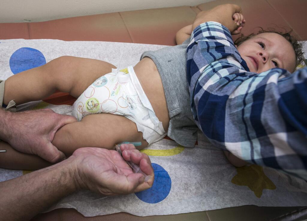 In this Thursday, Jan. 29, 2015, photo, pediatrician Charles Goodman vaccinates 1-year-old Cameron Fierro with the measles-mumps-rubella vaccine, or MMR vaccine, at his practice in Northridge, Calif. The largest measles outbreak in recent memory occurred in Ohio's Amish country where 383 people were sickened last year after several traveled to the Philippines and brought the virus home. While that outbreak got the public's attention, it's nowhere near the level as the latest measles outbreak that originated at Disneyland in December, prompting politicians to weigh in and parents to voice their vaccinations views on Internet message boards. (AP Photo/Damian Dovarganes)