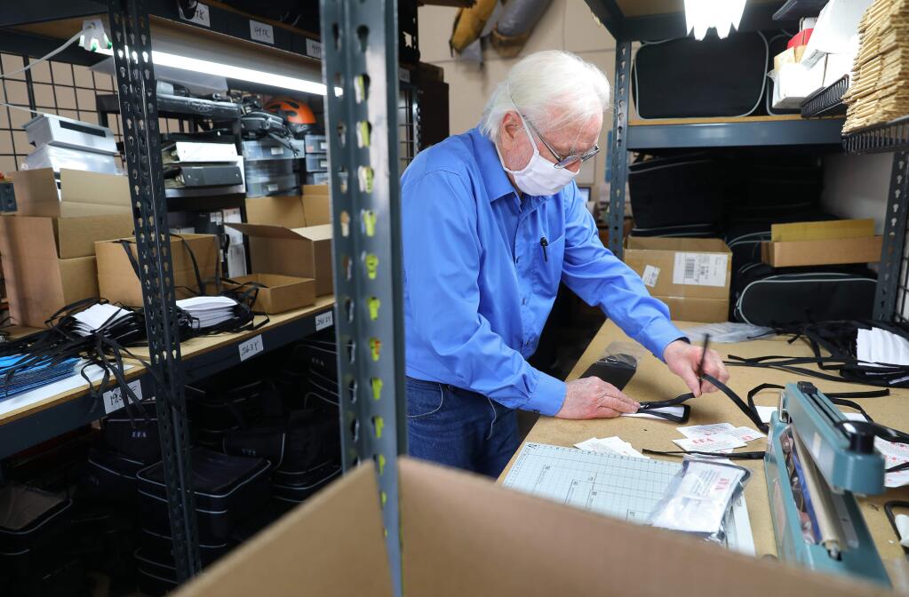 Richard Battles places masks in packaging to be shipped to a customer at RKA Luggage in Windsor on Wednesday, April 22, 2020. (Christopher Chung/ The Press Democrat)