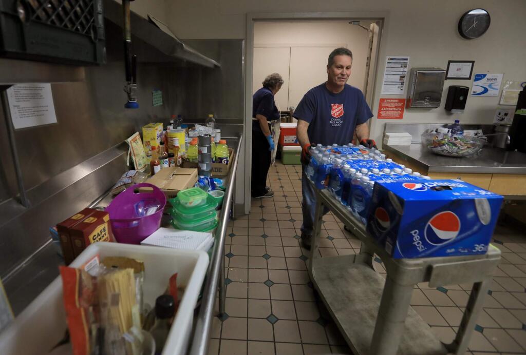 The Finely Center in Santa Rosa is now clear of fire evacuees, Wednesday Nov, 9, 2017, but Salvation Army staffer Derick Orr collects unused items, as Finley Center volunteer Nancy Nordby cleans. (Kent Porter / The Press Democrat) 2017