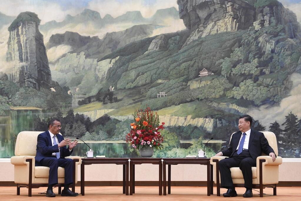 FILE - In this Jan. 28, 2020, file photo, Tedros Adhanom Ghebreyesus, director general of the World Health Organization, left, meets with Chinese President Xi Jinping at the Great Hall of the People in Beijing. Throughout January, the World Health Organization publicly praised China for what it called a speedy response to the new coronavirus. It repeatedly thanked the Chinese government for sharing the genetic map of the virus “immediately” and said its work and commitment to transparency were “very impressive, and beyond words.” But behind the scenes, there were significant delays by China and considerable frustration among WHO officials over the lack of outbreak data, The Associated Press has found. (Naohiko Hatta/Pool Photo via AP, File)