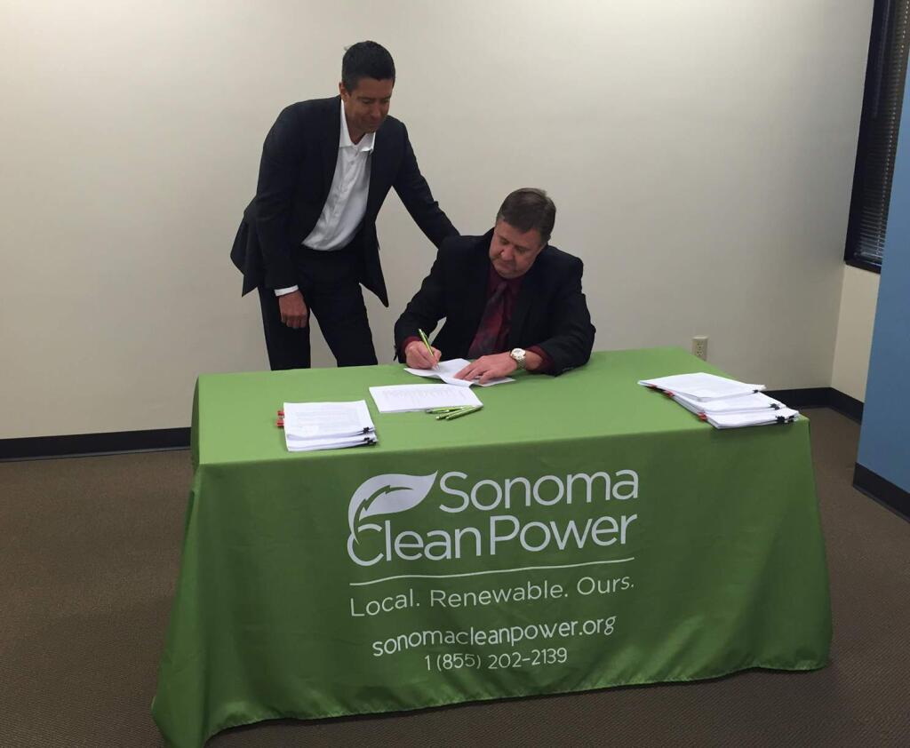 David Cook (seated), chairman of Sonoma Clean Power's Procurement Ad Hoc Committee, and Pristine Sun CEO Troy Helming sign a contract for floating solar arrays on Feb. 26, 2015. (Sonoma Clean Power)