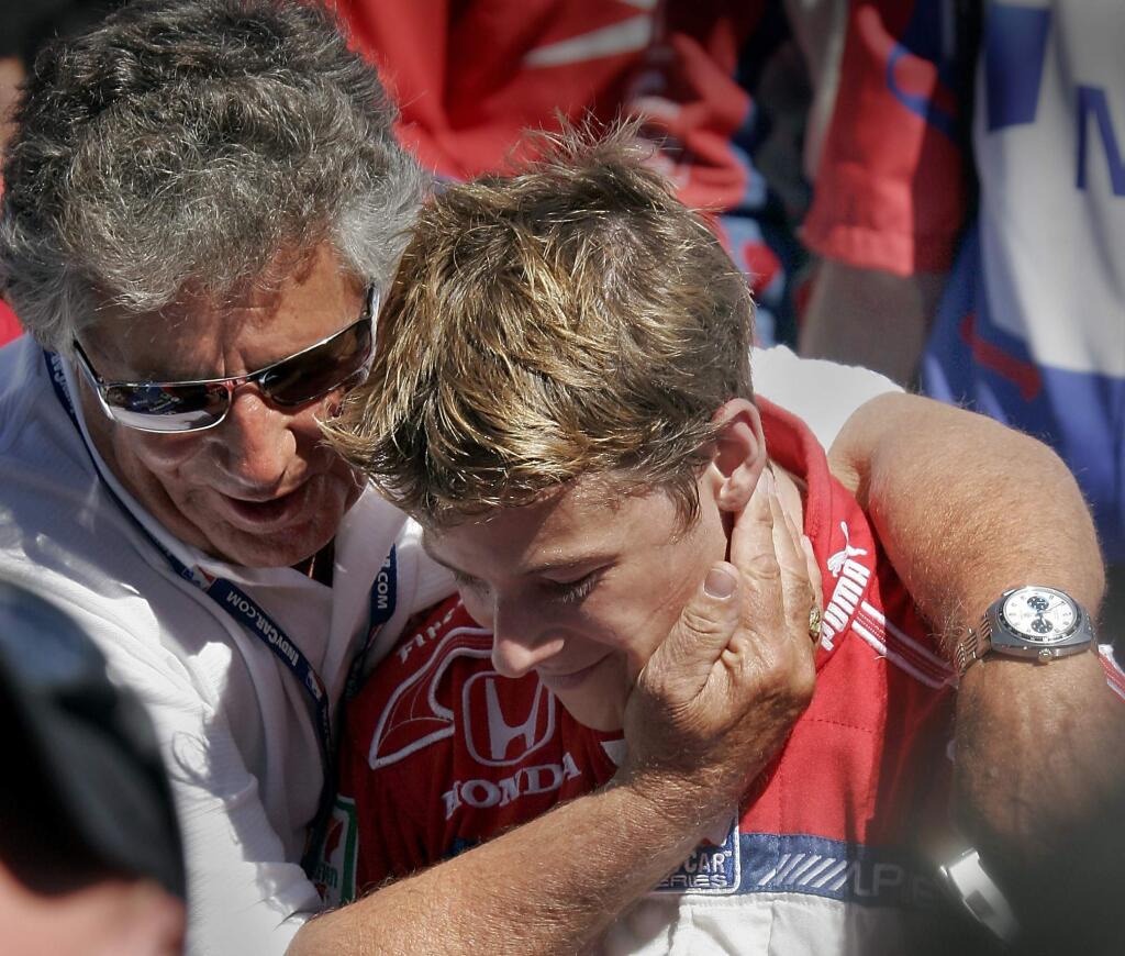 Marco Andretti, right, is hugged by his grandfather, Mario Andretti, winner of the 1969 Indy 500, as he sits in his car in the winner's circle following his victory at the Indy Grand Prix of Sonoma in 2006. (PRESS DEMOCRAT/ MARK ARONOFF)