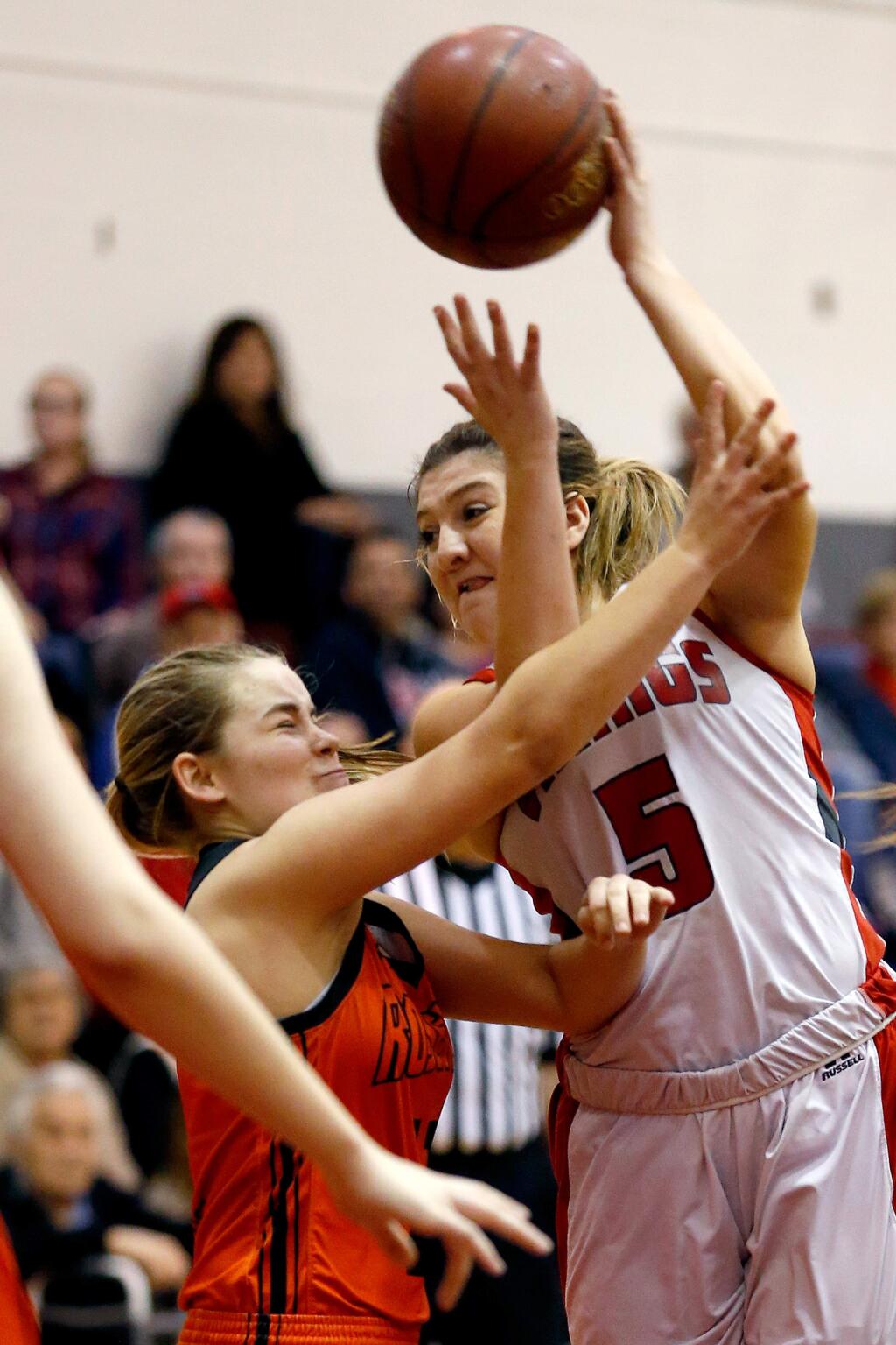 Montgomery's Julia Watson (5), right, dishes a pass toward the baseline while guarded by Roseville's Skyler Rubey (12) during the second half of the CIF NorCal Division II girls varsity basketball first-round playoff game between Roseville and Montgomery high schools in Santa Rosa, California on Wednesday, March 8, 2017. (Alvin Jornada / The Press Democrat)