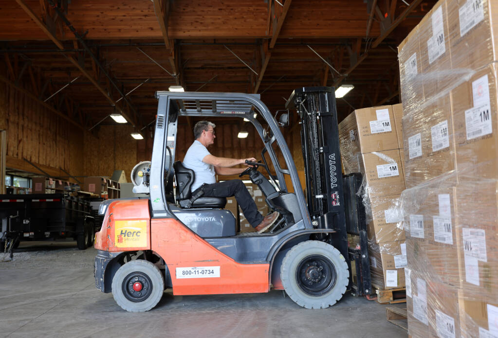 SCOE maintenance employee Jim Perreault moves boxes ofCOVID-19 test kits available for school districts to pickup from the Sonoma County Office of Education warehouse in Santa Rosa, Calif. on Thursday, August 4, 2022. (Beth Schlanker/The Press Democrat)