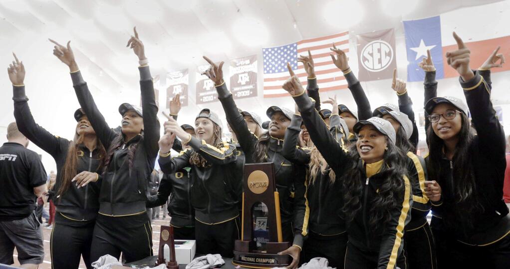 The Oregon women's track and field team celebrate their national championship with the trophy during the NCAA college indoor track and field championships Saturday, March 11, 2017, in College Station, Texas. (AP Photo/Michael Wyke)