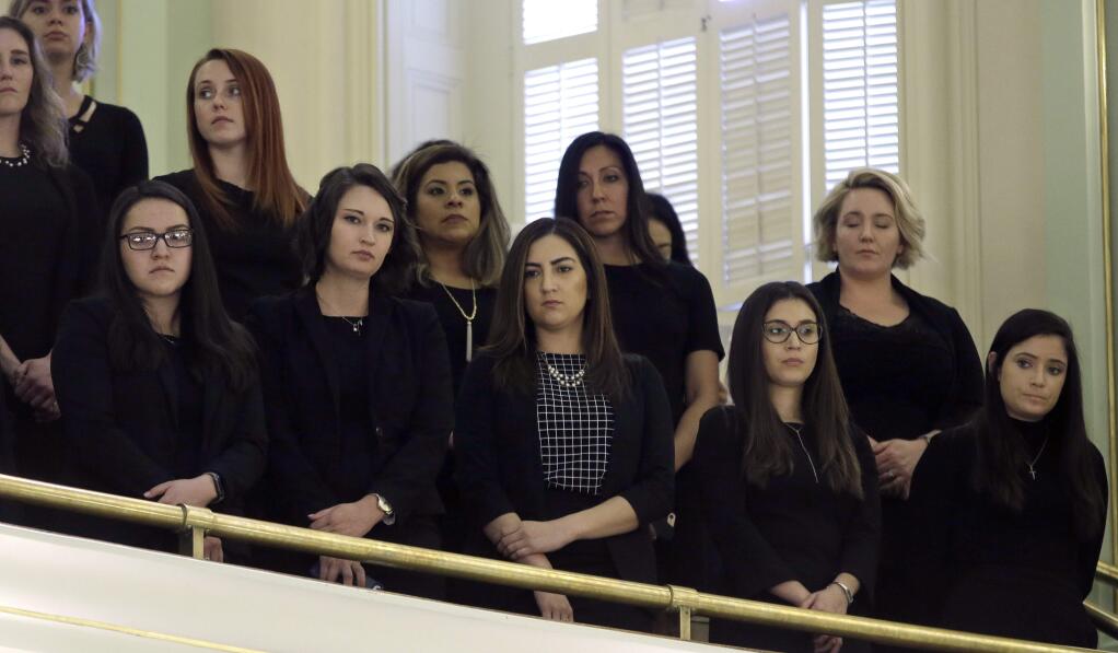 Women, dressed in black, stand in the Assembly gallery to show their support for measure to give whistleblower protection for legislative staff members, Monday, Feb. 5, 2018, in Sacramento, Calif. The bill, AB403, by Assemblywoman Melissa Melendez, R-Lake Elsinore, was approved by the Assembly and now goes to Gov. Jerry Brown. (AP Photo/Rich Pedroncelli)