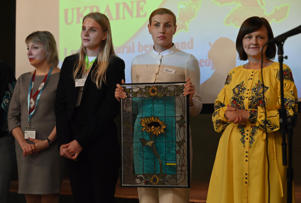 Olena Zhyvko, holding a stain glass given to her and her fellow Ukrainian professionals as a gift, from left, Hanna Yefimtseva, Daria Rubtsova and their facilitator Olga Tkachuk while visiting Sonoma County as part of the congressionally-sponsored program Open World and coordinated by Sebastopol World Friends; the group are here to study child and family counseling and all provided a presentation of their work in Ukraine at Sebastopol Grange Hall on Friday, Feb. 2, 2024 in Sebastopol. (Erik Castro / For The Press Democrat)