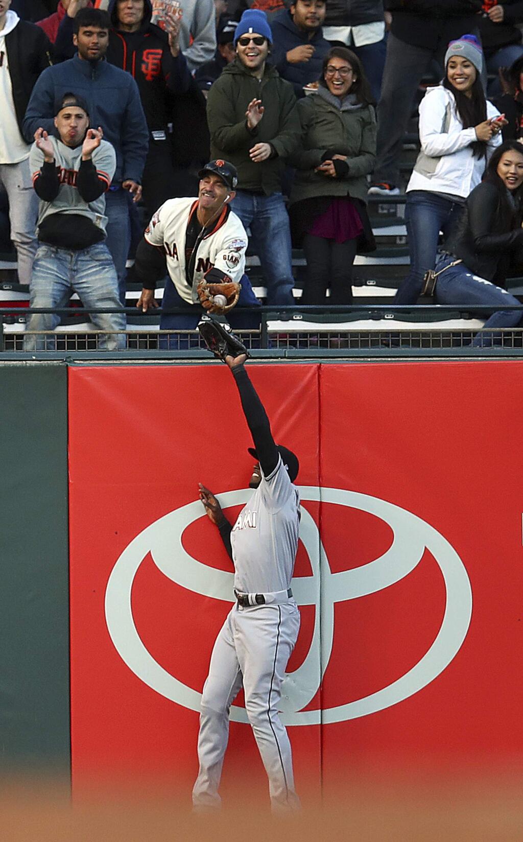 A fan catches a two-run home run hit by San Francisco Giants' Pablo Sandoval over Miami Marlins left fielder Cameron Maybin in the second inning of a baseball game Monday, June 18, 2018, in San Francisco. (AP Photo/Ben Margot)