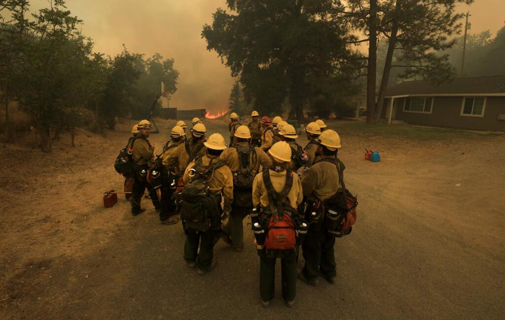 At the Upper Lake Rancheria, a crew of Mendocino National Forest hotshots band up to protect structures as the Ranch fire rolls in to the outskirts of Upper Lake, Monday, July 30, 2018. (Kent Porter / The Press Democrat) 2018