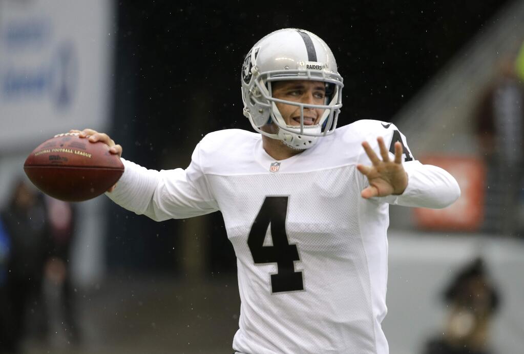 Oakland Raiders quarterback Derek Carr scrambles to pass against the Seattle Seahawks in the first half of an NFL football game, Sunday, Nov. 2, 2014, in Seattle. (AP Photo/Elaine Thompson)