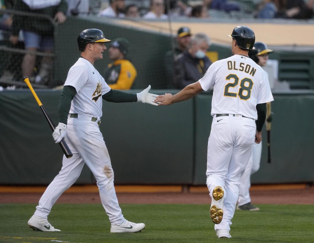 The Oakland Athletics’ Matt Olson, right, is congratulated by Matt Chapman after scoring on a single by Chad Pinder during the fourth inning against the Arizona Diamondbacks on Tuesday, June 8, 2021, in Oakland. (Tony Avelar / ASSOCIATED PRESS)