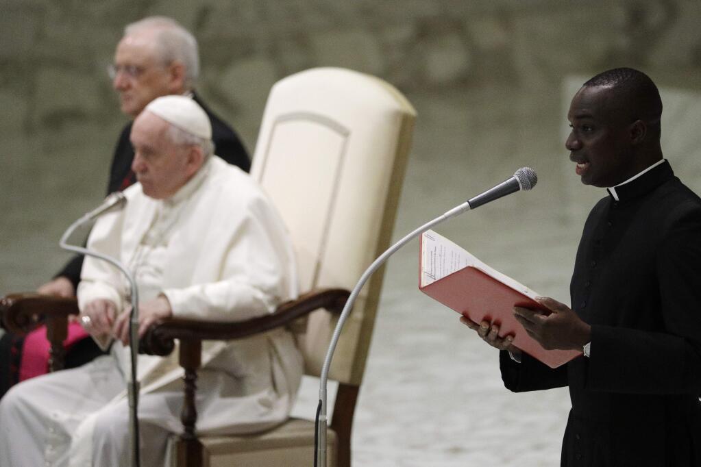 A priest reads Pope Francis' message for French pilgrims attending the weekly general audience at the Vatican, Wednesday, Feb. 12, 2020. (AP Photo/Gregorio Borgia)