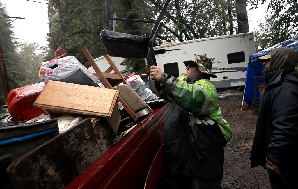 Darby Williams moves his belongings from the Mirabel Trailer Park near Forestville, Wednesday, Jan. 4, with the help of Steven Owens as the Russian River continues to rise. (Kent Porte r /The Press Democrat)