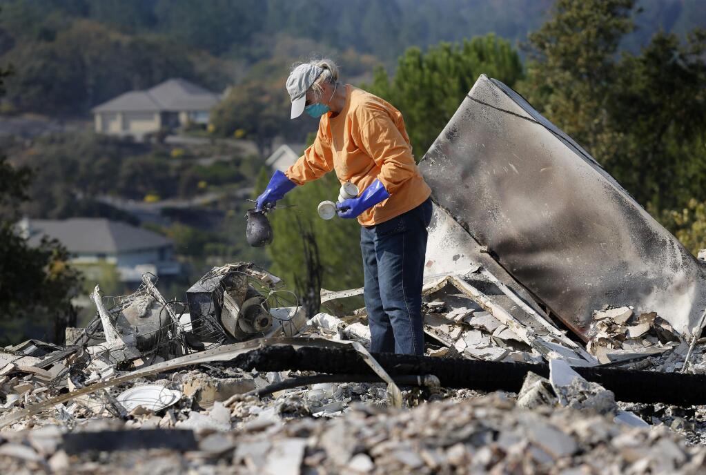 Supervisor Susan Gorin of the First District looks for anything to salvage among the charred remains of her home in the Oakmont area of Santa Rosa, on Wednesday, October 18, 2017. She had been planning an energy-efficient remodel, but the fire means she can start from scratch with an energy-efficient home. (BETH SCHLANKER/ The Press Democrat)