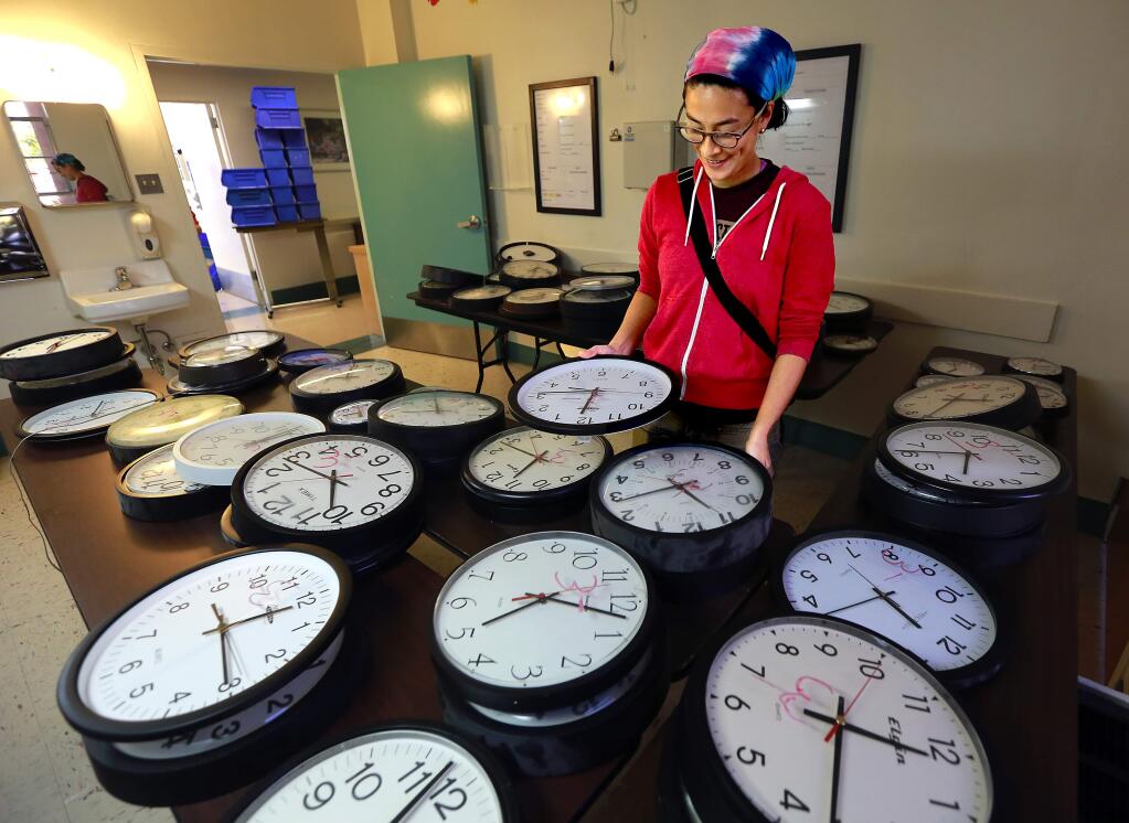 Emily Shaw, a former resident in the family medicine program at Sutter Hospital, looks through dozens of wall clocks during a sale of items from the old Sutter Hospital in Santa Rosa on Saturday, November 22, 2014.