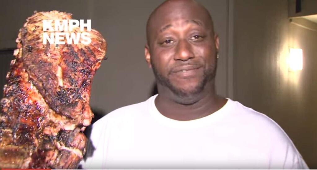 A screengrab from a KMPH video shows Robert Wright and the rack of ribs he rescued from a burning building in Fresno on Tuesday morning. (KMPH via YouTube)