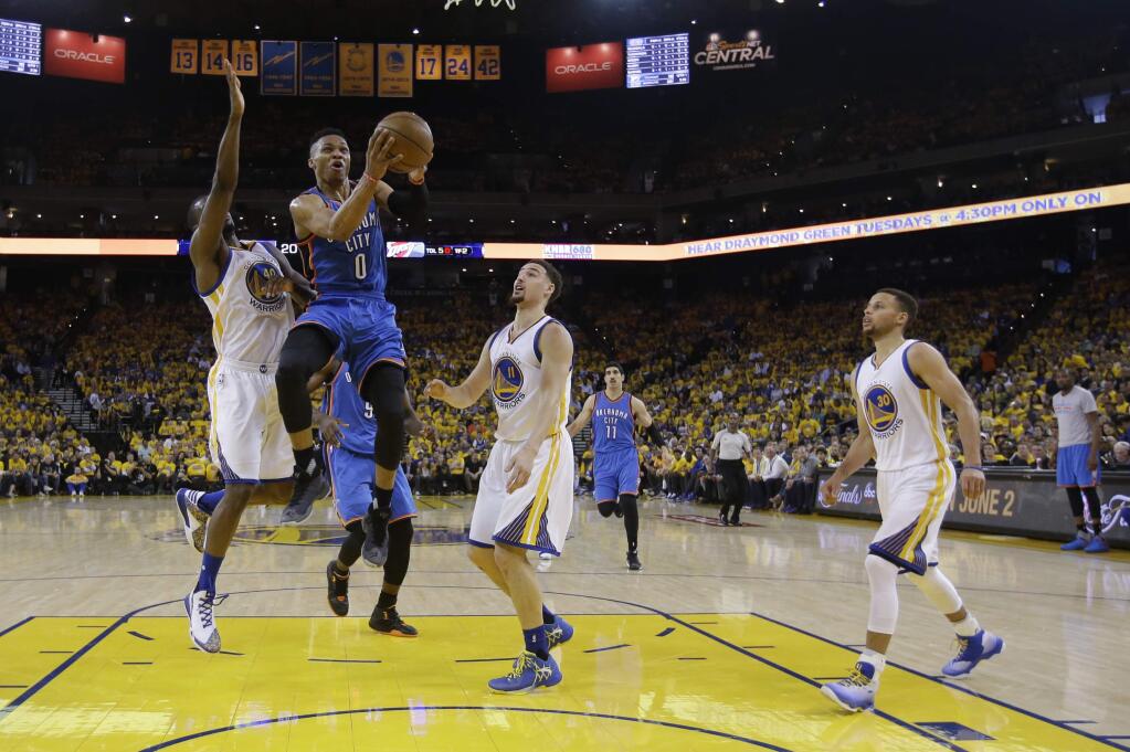Oklahoma City Thunder's Russell Westbrook (0) drives past Golden State Warriors' Harrison Barnes (40), Klay Thompson (11) and Stephen Curry (30) during the first half in Game 1 of the NBA basketball Western Conference finals Monday, May 16, 2016, in Oakland, Calif. (AP Photo/Marcio Jose Sanchez)