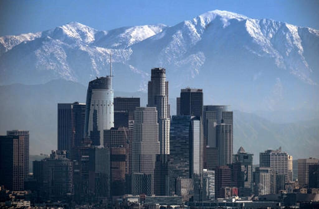 FILE - This Jan. 25, 2017 file photo shows a snow covered Mount Baldy, the highest peak among the San Gabriel Mountains behind downtown Los Angeles. Searchers have found the body of a veteran hiker who vanished while climbing the 10,000-foot (3,000-meter) mountain just northeast of Los Angeles. Seuk 'Sam' Kim, had hiked to the top of Mount Baldy in the San Gabriel Mountains more than 700 times before he went missing last week. (AP Photo/Richard Vogel, File)