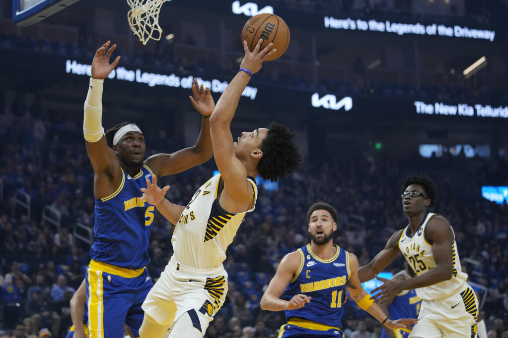 Indiana Pacers guard Andrew Nembhard shoots while defended by Golden State Warriors center Kevon Looney (5) during the first half of an NBA basketball game in San Francisco, Monday, Dec. 5, 2022. (AP Photo/Godofredo A. Vásquez)