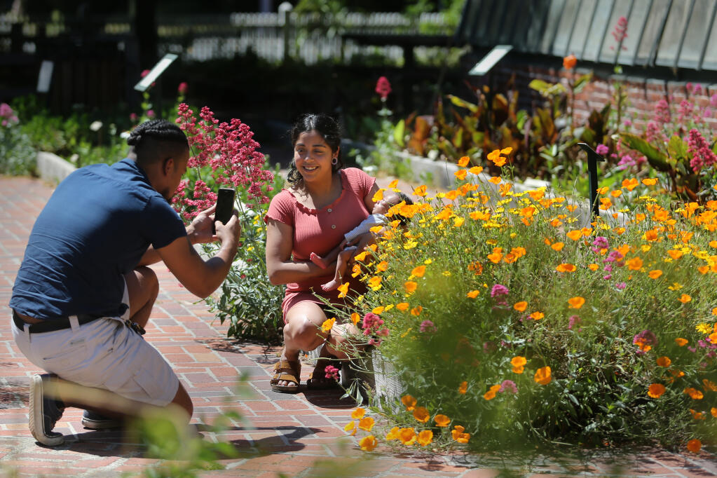Peter Scott takes a photo of Sarahi Torres and their 1-month-old son Onyx Scott-Torres at Luther Burbank Home and Gardens in Santa Rosa, California on Sunday, May 2, 2021. (Beth Schlanker/ The Press Democrat)