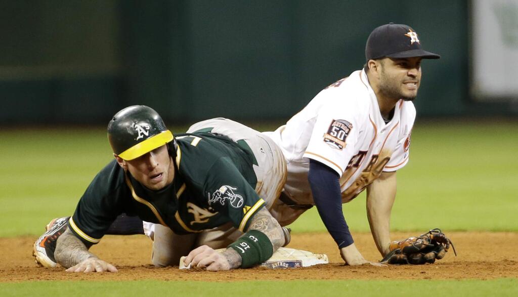 Houston Astros second baseman Jose Altuve (27) watches his throw to first after Oakland Athletics' Brett Lawrie slid into second base during the ninth inning of a baseball game Tuesday, May 19, 2015, in Houston. Lawrie was out at second and Mark Canha was out at first on the double play. The Astros won 6-4. (AP Photo/David J. Phillip)