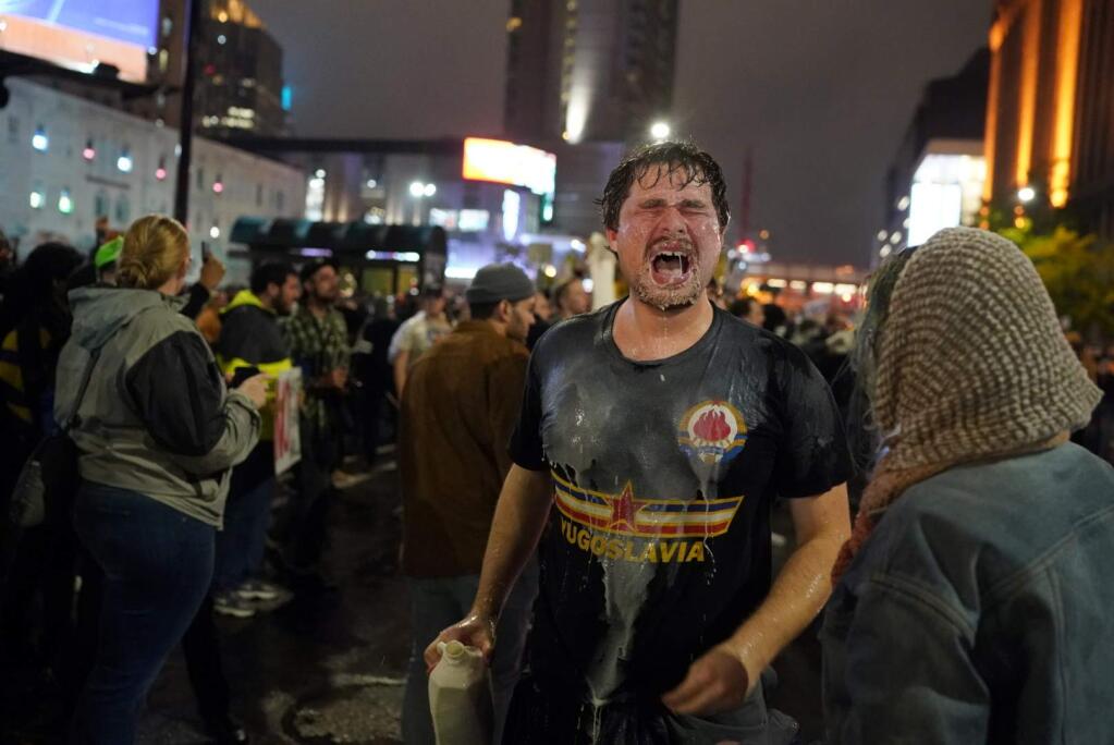 A protester poured milk on his face after being pepper sprayed by police outside the Target Center as President Donald Trump attends a campaign rally Thursday, Oct. 10, 2019, in Minneapolis. Protesters got into a brief confrontation with police outside Trump's rally after some of the demonstrators set Trump hats on fire. (Renee Jones Schneider/Star Tribune via AP)