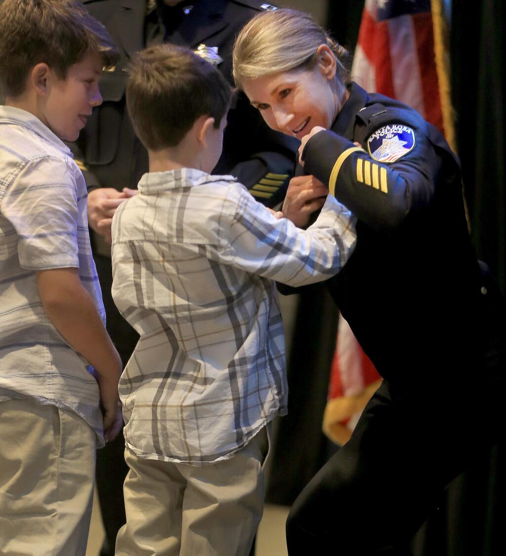 Santa Rosa Police Department acting Lieutenant Jeneane Kucker is pinned by her sons Ryan, 10, left and Gavin, 8, as she is promoted to permanent lieutenant during a ceremony at the Luther Burbank Center for the Arts in Santa Rosa on Tuesday, Sept. 3, 2019. (KENT PORTER/ PD)