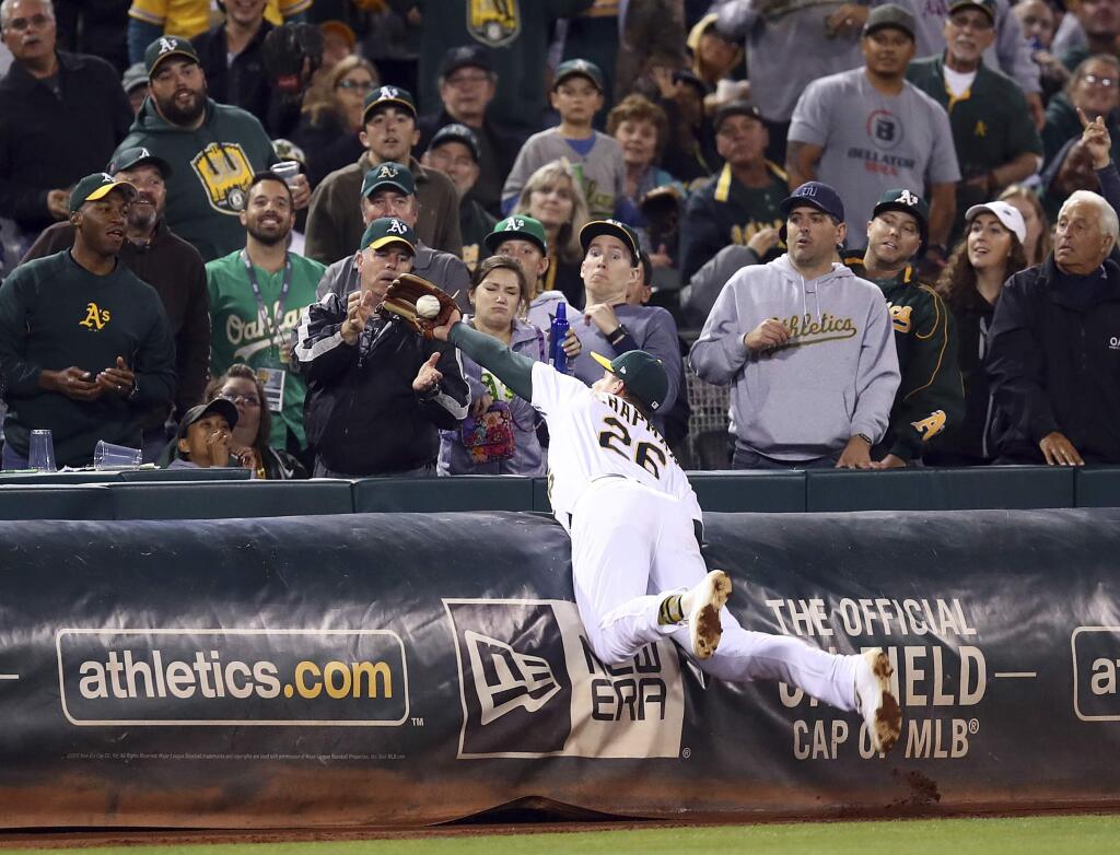 The Oakland Athletics' Matt Chapman makes the catch on a foul ball hit by the Seattle Mariners' Robinson Cano in the eighth inning Tuesday, Aug. 14, 2018, in Oakland. (AP Photo/Ben Margot)