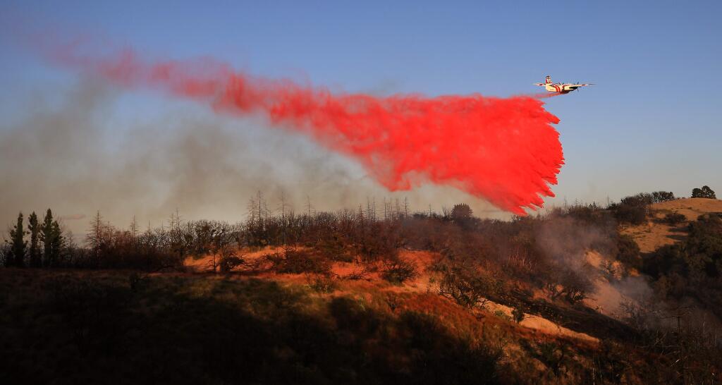 A pilot in an S2-T Cal Fire air tanker makes a drop on the Redwood fire off Redwood Hill Road east of Santa Rosa, Monday, Sept. 16, 2019. (Kent Porter / The Press Democrat) 2019