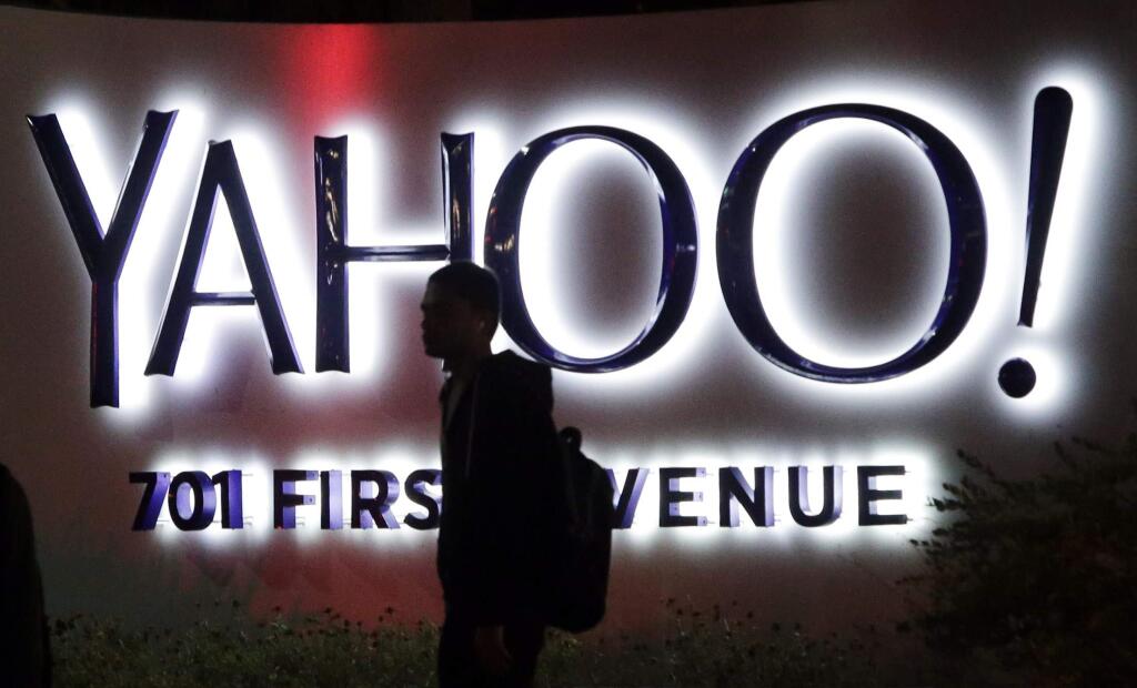 In this Nov. 5, 2014 photo, a person walks in front of a Yahoo sign at the company's headquarters in Sunnyvale, Calif. (AP Photo/Marcio Jose Sanchez)