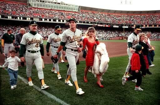 In this photo taken on Oct. 17, 1989, Oakland A's star Jose Canseco walks off the field with his wife Ester and other A's players before the start of the World Series at Candlestick Park in San Francisco. Oct. 17, 2019 marked the 30th anniversary of the Loma Prieta earthquake. (AP Photo/Contra Costa Times, Dan Rosenstrauch)