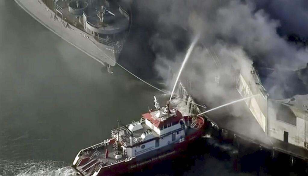 First responders battle a massive fire that erupted at a warehouse early Saturday, May 23, 2020 in San Francisco. Arriving crews were confronted with towering flames engulfing the warehouse. (KPIX-TV CBS-Viacom via AP)