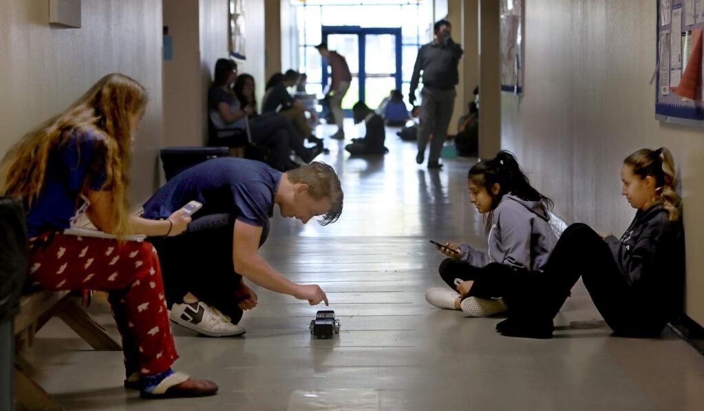 Technology High School students Hannah Menth and Andrew Helgren, left, and Aveen Dulai, Samantha Dickson participate in a momentum experiment in the hallways of the school that is located on the Sonoma State University Campus, Monday, April 16, 2018 in Rohnert Park. (Kent Porter / The Press Democrat) 2018