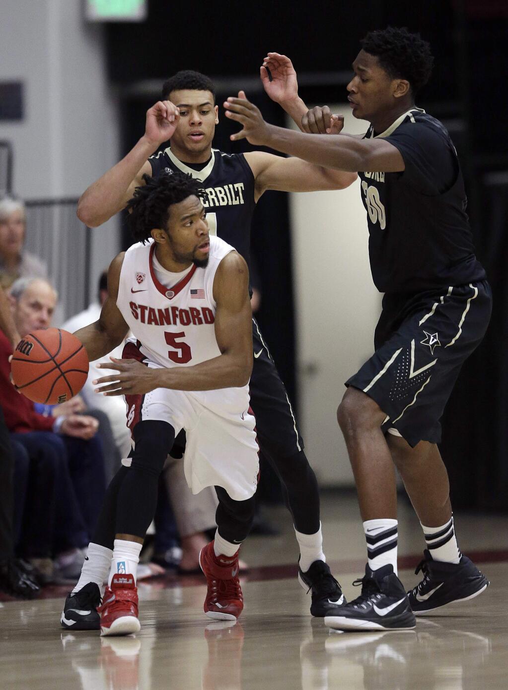 Stanford's Chasson Randle (5) dribbles as he is guarded by Vanderbilt's Wade Baldwin IV, rear, and Damian Jones during the first half of an NCAA college basketball game in the National Invitation Tournament in Stanford, Calif., Tuesday, March 24, 2015. (AP Photo/Jeff Chiu)